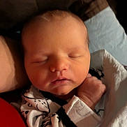 Raynor is registered to the contest to win money with this photo: baby, newborn, sleeping, infant, face, hand, onesie, clothing, blanket, closeup, person, cute, soft, rest, peaceful, skin, head, indoors, warm, cozy