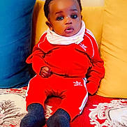 Maryam participe au concours pour gagner de l'argent avec cette photo : adidas, baby, blue_pillow, carpet, child, cozy, cute, expression, furniture, home, indoor, infant, patterned_carpet, person, pillow, portrait, red_tracksuit, seated, socks, yellow_pillow