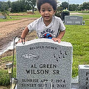 Kaimani is registered to the contest to win money with this photo: afro_hair, boy, casual_clothing, cemetery, child, clouds, daytime, funeral, grass, graveyard, headstone, memorial, monument, mourning, nature, outdoor, person, sky, tombstone, trees