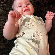 Xavier is registered to the contest to win money with this photo: baby, child, closeup, clothing, cute, fabric, face, hand, indoors, infant, lying_down, onesie, pajamas, person, resting, sleepy, smile, soft_light, winnie_the_pooh, young_child