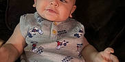 Xavier is registered to the contest to win money with this photo: baby, child, clothing, couch, cute, dark_background, drool, expression, face, indoor, infant, mickey_mouse, onesie, person, portrait, relaxed, short_sleeves, sitting, smiling, young_child