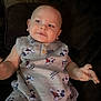 baby, child, clothing, couch, cute, dark_background, drool, expression, face, indoor, infant, mickey_mouse, onesie, person, portrait, relaxed, short_sleeves, sitting, smiling, young_child