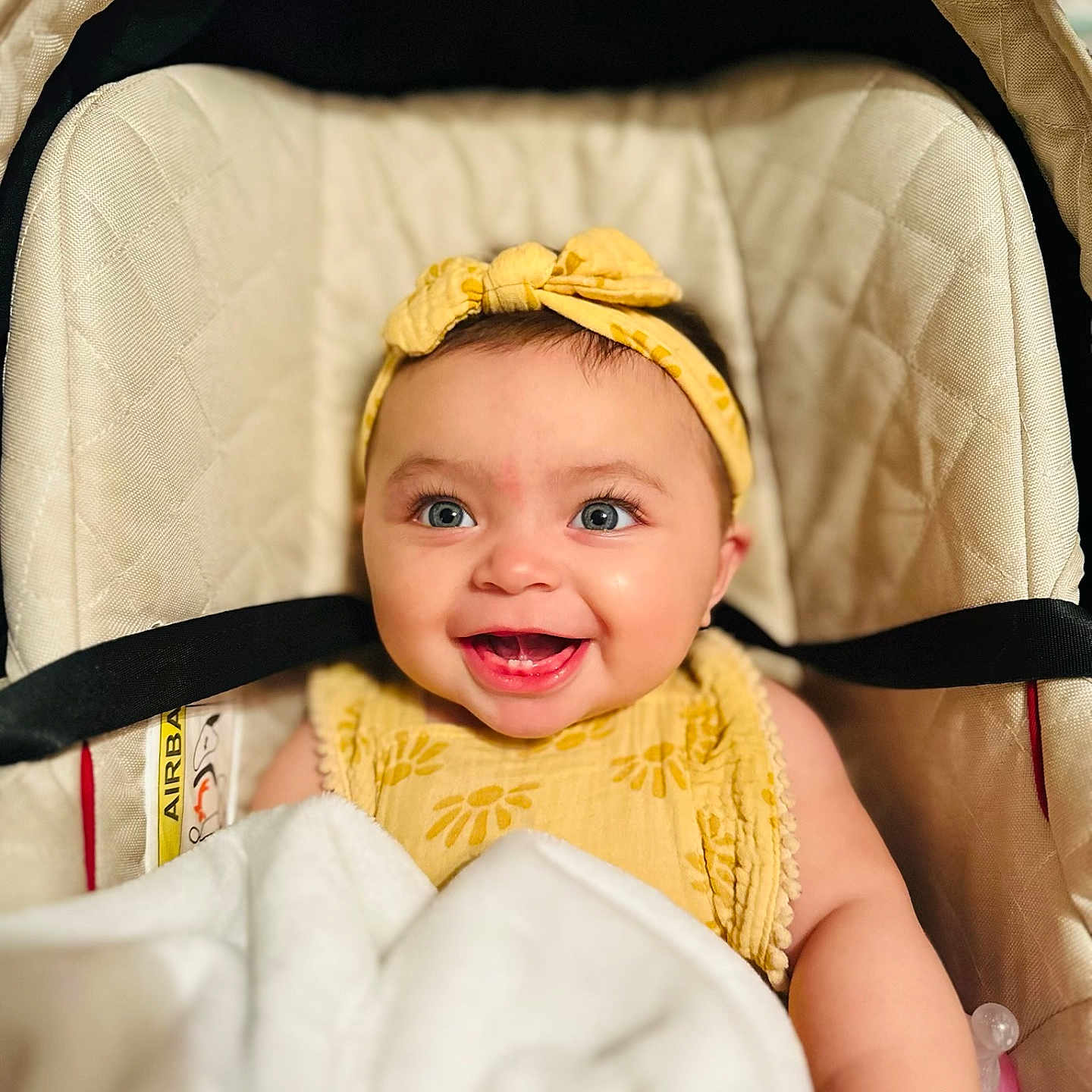 Everlee is registered to the contest to win money with this photo: baby, baby_girl, blanket, blue_eyes, car_seat, child, clothing, cozy, cute, face, happy, headband, indoor, infant, person, portrait, smiling, soft, toddler, yellow