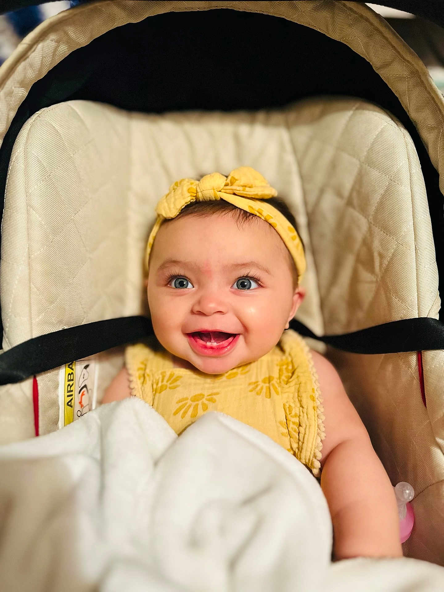 Everlee is registered to the contest to win money with this photo: baby, smiling, headband, yellow, car_seat, blanket, blue_eyes, cute, infant, happy, clothing, child, portrait, indoor, face, person, baby_girl, soft, cozy, toddler