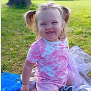 Orlagh is registered to the contest to win money with this photo: toddler, child, smiling, outdoor, grass, blanket, pigtails, pink_clothing, shorts, playful, happy, sunlight, nature, park, young_child, person, sitting, face, cute, daytime