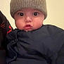 baby, child, face, hat, knit_hat, jacket, clothing, wide_eyes, portrait, indoor, cute, infant, young_child, expression, looking, person, headwear, warm_clothing, closeup, soft_lighting