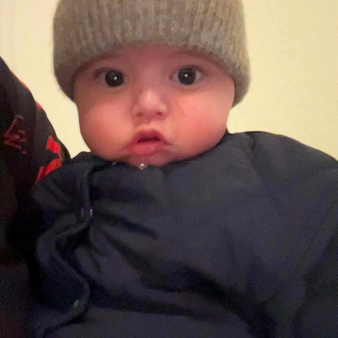 Mallo participe au concours pour gagner de l'argent avec cette photo : baby, child, closeup, clothing, cute, expression, face, hat, headwear, indoor, infant, jacket, knit_hat, looking, person, portrait, soft_lighting, warm_clothing, wide_eyes, young_child