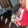 Simon is registered to the contest to win money with this photo: woman, cat, kitten, smiling, indoor, couch, leggings, tshirt, sitting, relaxed, curtains, cushions, black_clothing, red_tshirt, face, pet, sleeping, comfort, home, leisure