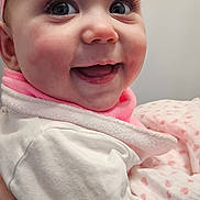 Cléa a rejoint le concours — aidez-le/la à gagner de superbes lots ! baby, infant, smiling, headband, pink, blanket, bib, hand, eyes, eyelashes, cheeks, close_up, portrait, holding, parent_hand, clothing, rosy_cheeks, adorable, indoor, happy