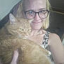 Garfield joined the competition — help win amazing prizes! animal, blonde_hair, casual, cat, close_up, companion, friendly, furry, glasses, holding, home, indoor, orange_cat, person, pet, portrait, relaxed, smile, tank_top, woman