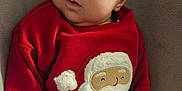 Ellianna is registered to the contest to win money with this photo: baby, infant, red_sweater, santa_claus, headband, bow, cute, face, expression, clothing, soft_surface, indoors, child, person, portrait, holiday, christmas, cozy, warm, lying_down
