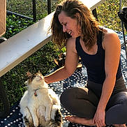 Cedar joined the competition — help win amazing prizes! woman, cat, outdoor, grass, bench, rug, sunlight, smiling, petting, happy, long_hair, casual_clothing, barefoot, relaxed, playful, fluffy_cat, tabby, sitting, nature, leisure