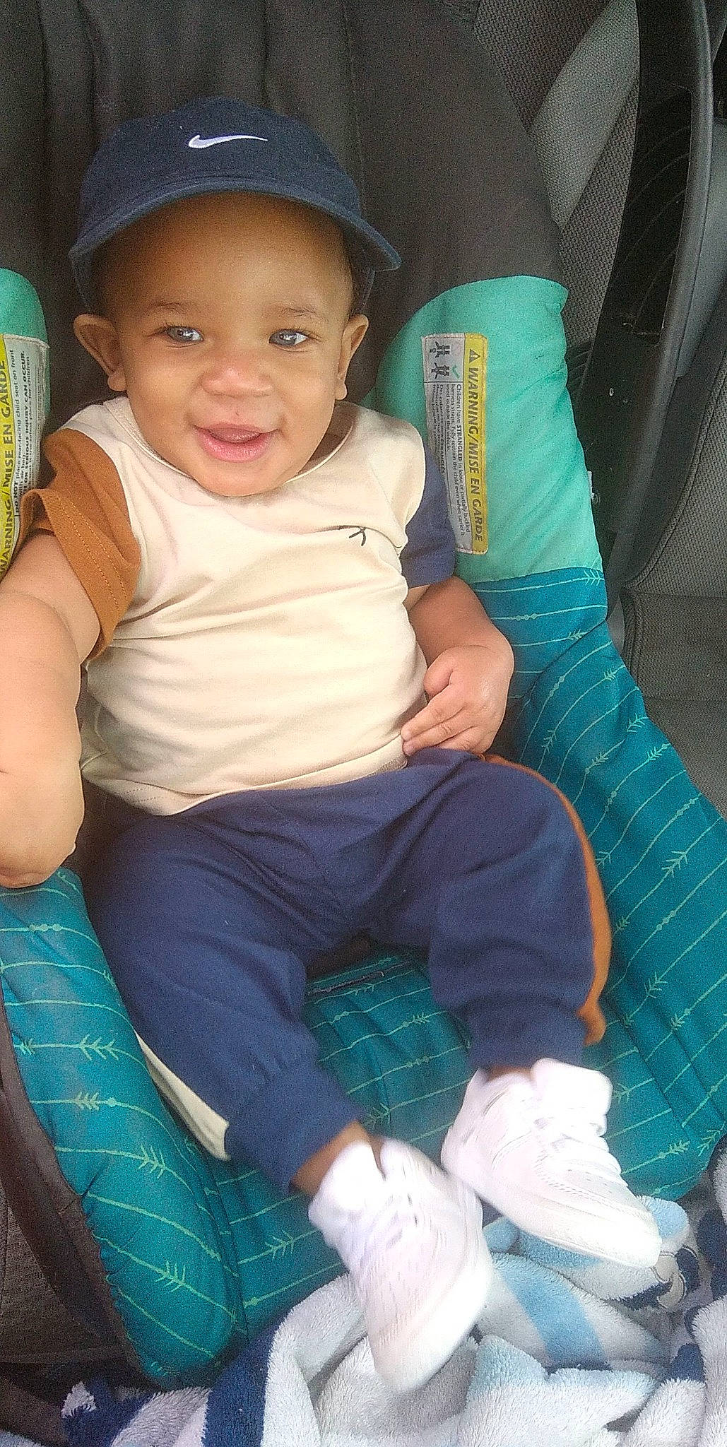 August is registered to the contest to win money with this photo: baby_toddler_clothing, blue, cap, cheek, comfort, cool, eye, green, happy, hat, iris, joy, lap, leg, organ, person, product, skin, smile, thigh