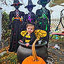 Odessa joined the competition — help win amazing prizes! child, baby, bee_costume, cauldron, pumpkin, carved_pumpkin, witch_figure, witch_hat, halloween, outdoor, fall_leaves, decorative_lights, porch, swing, yard, costume, face, smile, plastic, lattice_fence