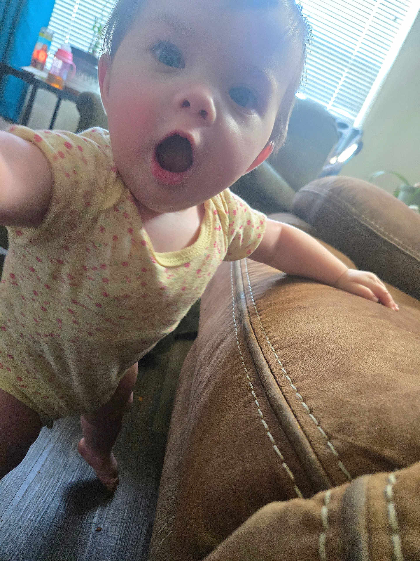 Odessa joined the competition — help win amazing prizes! baby, infant, child, surprised_face, mouth_open, eyes, onesie, living_room, sofa, couch, upholstery, wooden_floor, hand, arm, close_up, portrait, sippy_cup, blinds, furniture, home_interior