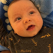 Adam participe au concours pour gagner de l'argent avec cette photo : baby, blue_blanket, child, closeup, clothing, curious_expression, cute, eyes, face, happy, indoors, infant, lying_down, mouth, portrait, skin, smiling, soft_texture, text_print, young_child