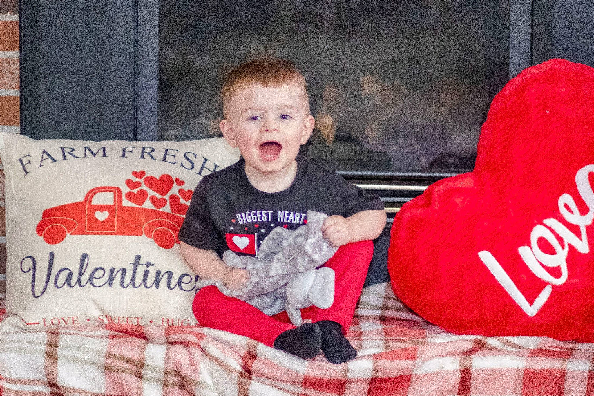 Cash is registered to the contest to win money with this photo: baby_toddler_clothing, black, child, christmas, christmas_eve, comfort, couch, event, happy, holiday, lap, mammal, person, pillow, red, sleeve, smile, t_shirt, textile, toddler