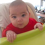 Kaïlyne a rejoint le concours — aidez-le/la à gagner de superbes lots ! baby, child, cozy, curious, expression, eyes, face, furniture, green_tray, hands, high_chair, indoor, infant, natural_light, person, portrait, red_clothing, skin, table, window
