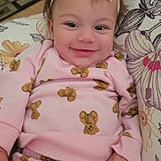 Kaliana is registered to the contest to win money with this photo: baby, bow, child, comfort, cushion, cute, face, floral_pattern, hand, happy, headband, indoors, infant, pink_clothing, portrait, relaxing, smile, soft_toys, teddy_bear_pattern, young_child