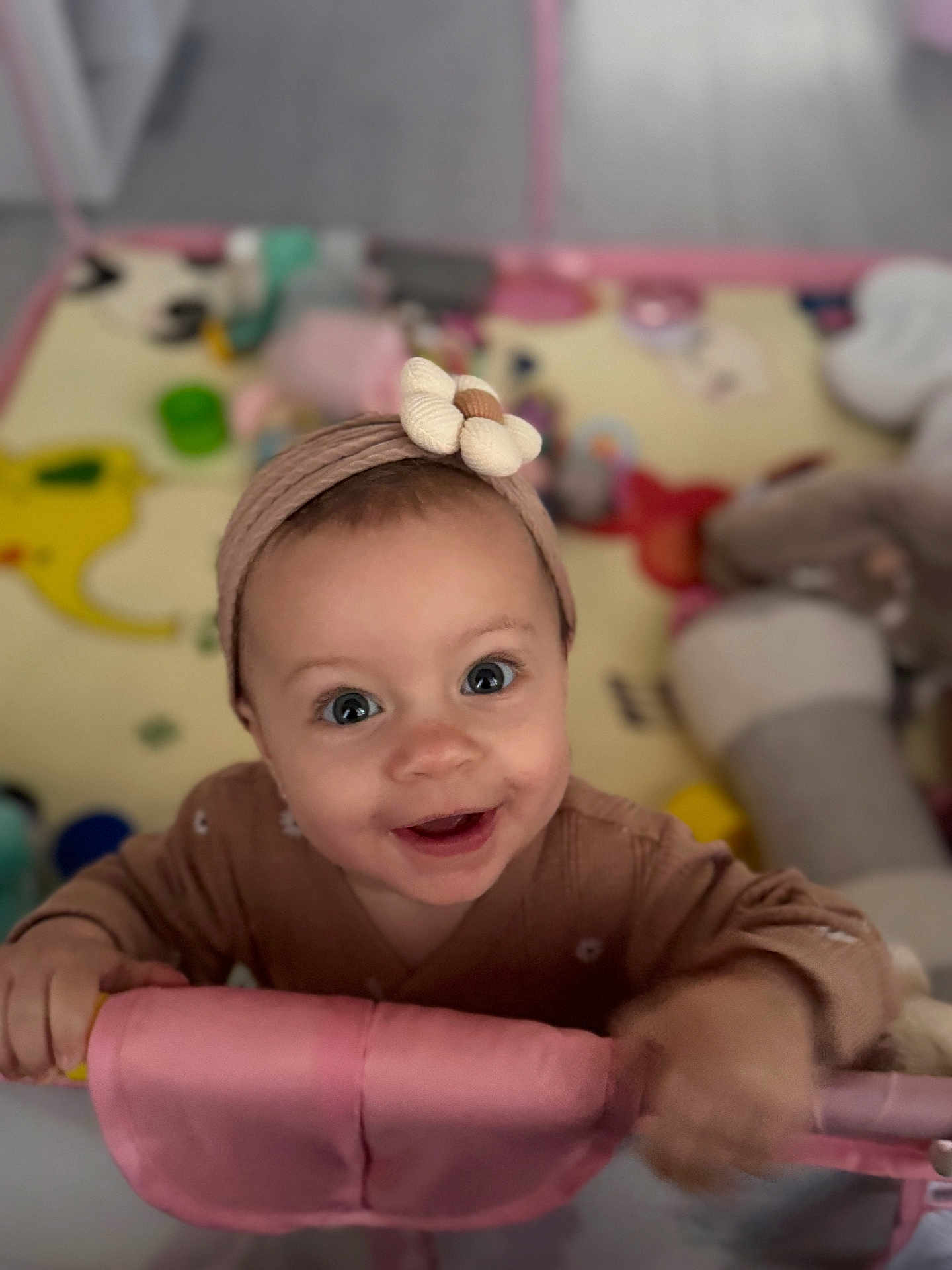 Jannah joined the competition — help win amazing prizes! baby, infant, child, smiling, big_eyes, headband, bow, playpen, playmat, toys, pink, onesie, hands, closeup, portrait, indoor, happy, looking_up, blurred_background, rosy_cheeks
