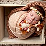 baby, blanket, closeup, cozy, cute, flower, giraffe, headband, indoor, infant, knit, newborn, peaceful, portrait, resting, sleeping, soft, toy, wooden_box, wrapped