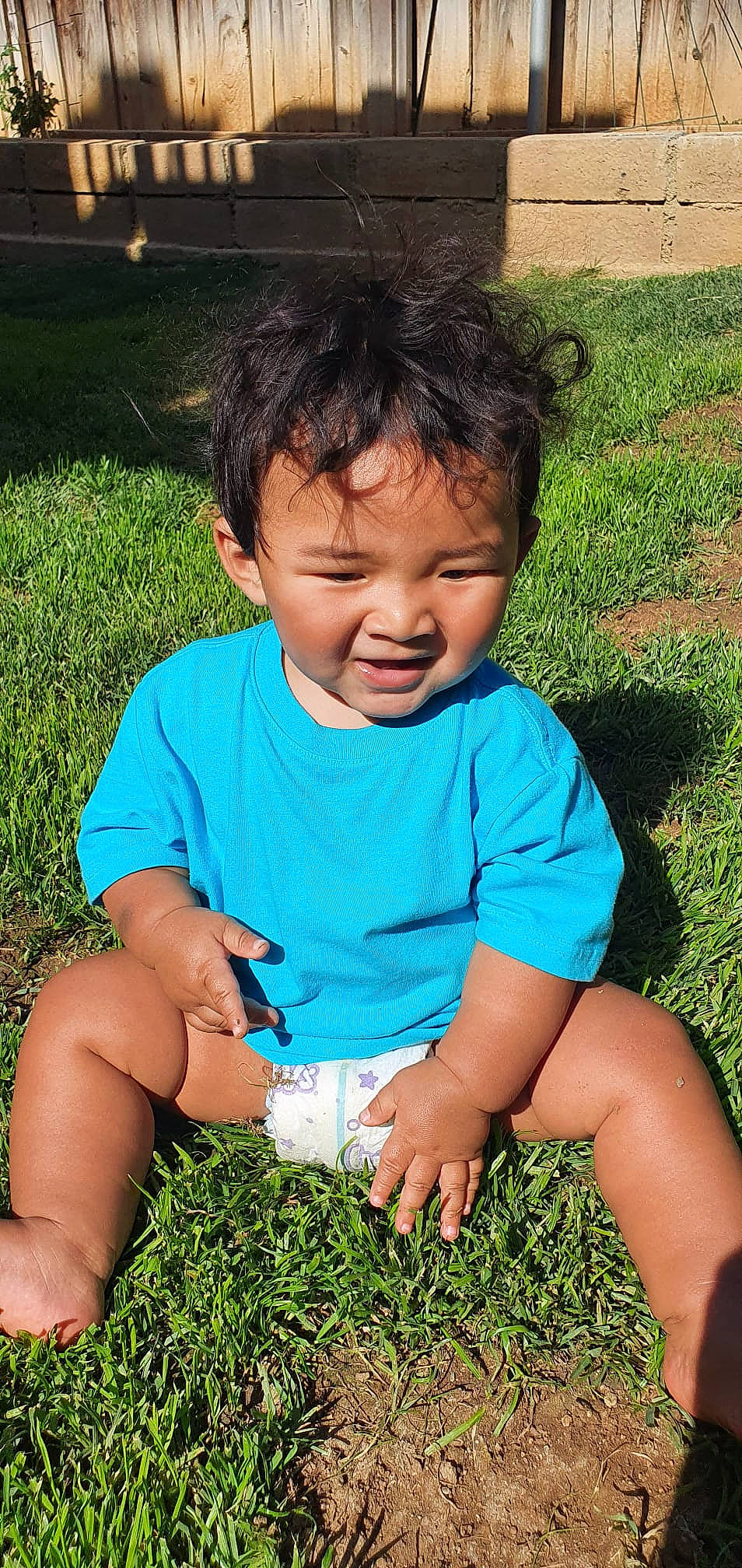 Zack is registered to the contest to win money with this photo: baby, baby_toddler_clothing, eye, finger, grass, hairstyle, hand, happy, iris, leaf, people, people_in_nature, person, photograph, plant, skin, smile, summer, sunlight, t_shirt