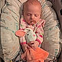 baby, sleeping, pacifier, plush_toy, bunny, blanket, cushion, infant, comfort, soft_toy, child, indoors, peaceful, cute, pink_clothing, patterned, cozy, rest, hands, head