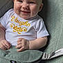 Vaughn is registered to the contest to win money with this photo: baby, smiling, infant, onesie, white_clothing, yellow_embroidery, baby_seat, green_cushion, happy, chubby_cheeks, hands, legs, closeup, portrait, cute, child, indoor, soft_lighting, comfort, seatbelt