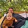 Oliver participe au concours pour gagner de l'argent avec cette photo : baby, child, man, smiling, hoodie, outdoor, bench, cushion, greenery, nature, happy, portrait, casual, relaxed, person, family, holding, daylight, wood, seating