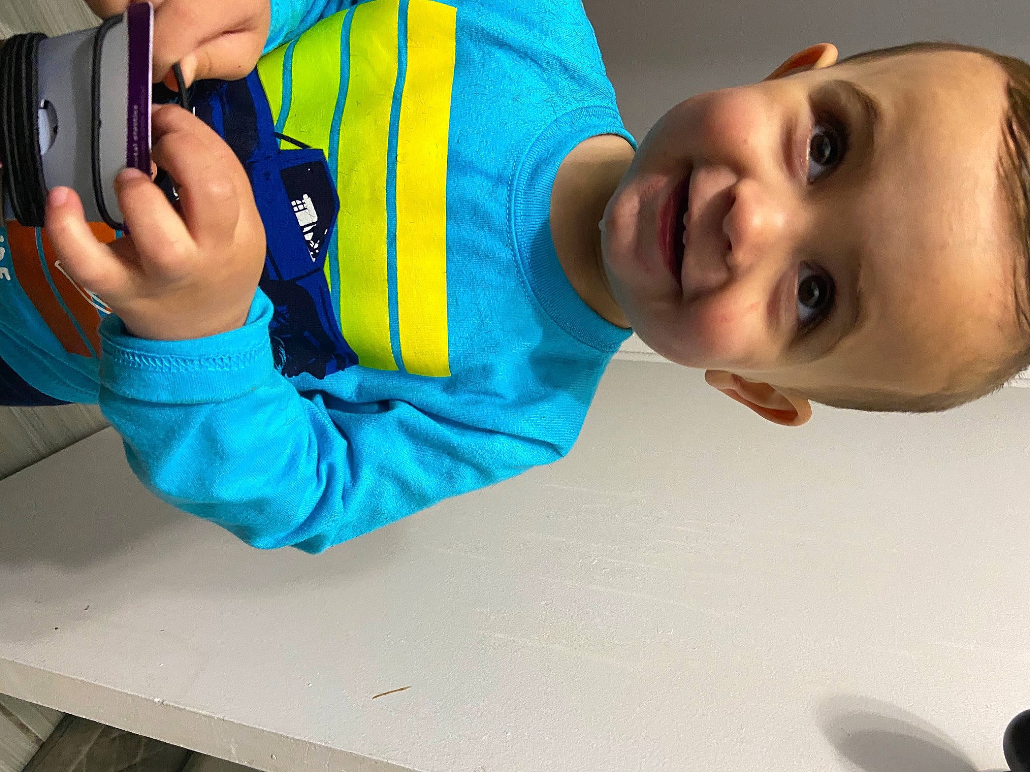 Louis is registered to the contest to win money with this photo: baby, baby_toddler_clothing, blue, camera, child, clothing, digital_camera, elbow, electric_blue, finger, hand, happy, joy, leisure, person, sleeve, smile, table, thumb, toddler