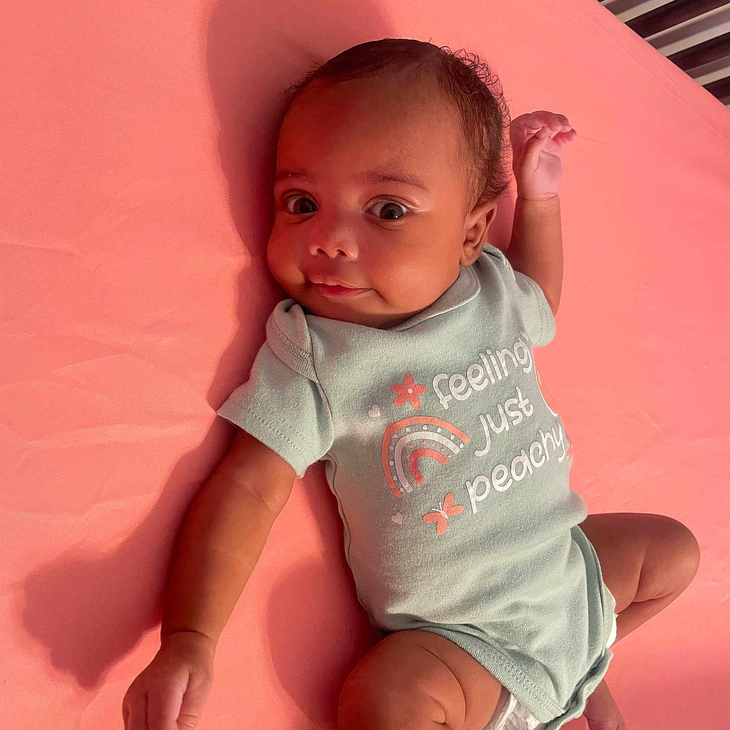 Shiloh is registered to the contest to win money with this photo: applique, baby, bodypart, clothing, face, finger, furniture, hand, happy, head, newborn, pattern, person, photography, portrait, shorts, sitting, sleeve, smile, t_shirt