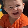Thomas joined the competition — help win amazing prizes! baby, child, smiling, laughing, portrait, close_up, orange_shirt, short_hair, sitting, hands, package, indoor, vertical_photo, social_media, text_overlay, happy, face, infant, bright_clothing, candid