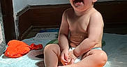 Thomas joined the competition — help win amazing prizes! baby, child, infant, laughing, smiling, sitting, diaper, indoor, sunlight, rainbow_rug, colorful, portrait, face, barefoot, happy, playroom, floor, orange_hat, home, candid