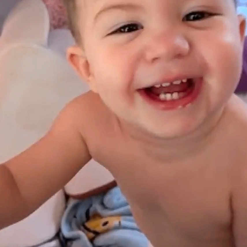 Thomas joined the competition — help win amazing prizes! baby, child, smiling, happy, portrait, close_up, face, teeth, eyes, indoor, bedroom, bed, blanket, sitting, baby_clothing, skin, brown_hair, photograph, text_overlay, social_media