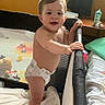 Thomas joined the competition — help win amazing prizes! baby, child, toddler, standing, smiling, indoors, playpen, diaper, bare_chested, toy, blanket, bedroom, window, sunlight, furniture, portrait, happy, infant, home, play_area