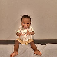 Ke'Vontae is registered to the contest to win money with this photo: toddler, child, smiling, sitting, shorts, shirt, barefoot, indoor, medical_table, paper_sheet, playful, happy, person, young_child, portrait, baby, furniture, wall, cute, hands