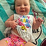 baby, smiling, child, infant, baby_shark, colorful_clothing, blanket, striped_blanket, cheerful, cute, happy, lying_down, indoors, person, playful, hand, face, shorts, toddler, casual