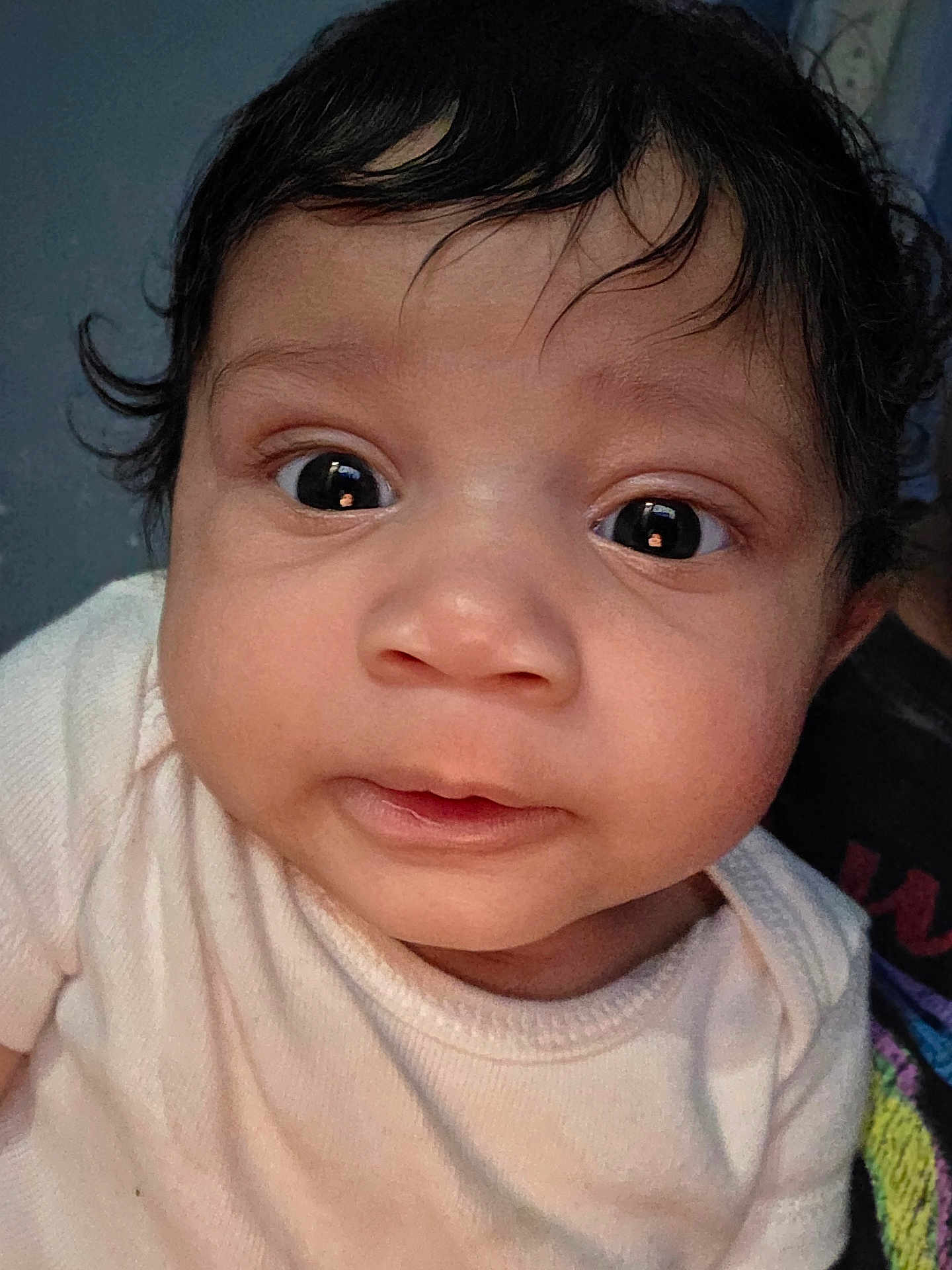 Daya is registered to the contest to win money with this photo: baby, close_up, face, infant, curious, wide_eyes, soft_clothing, skin, head, portrait, child, person, young, cute, expression, indoors, human, newborn, adorable, hair