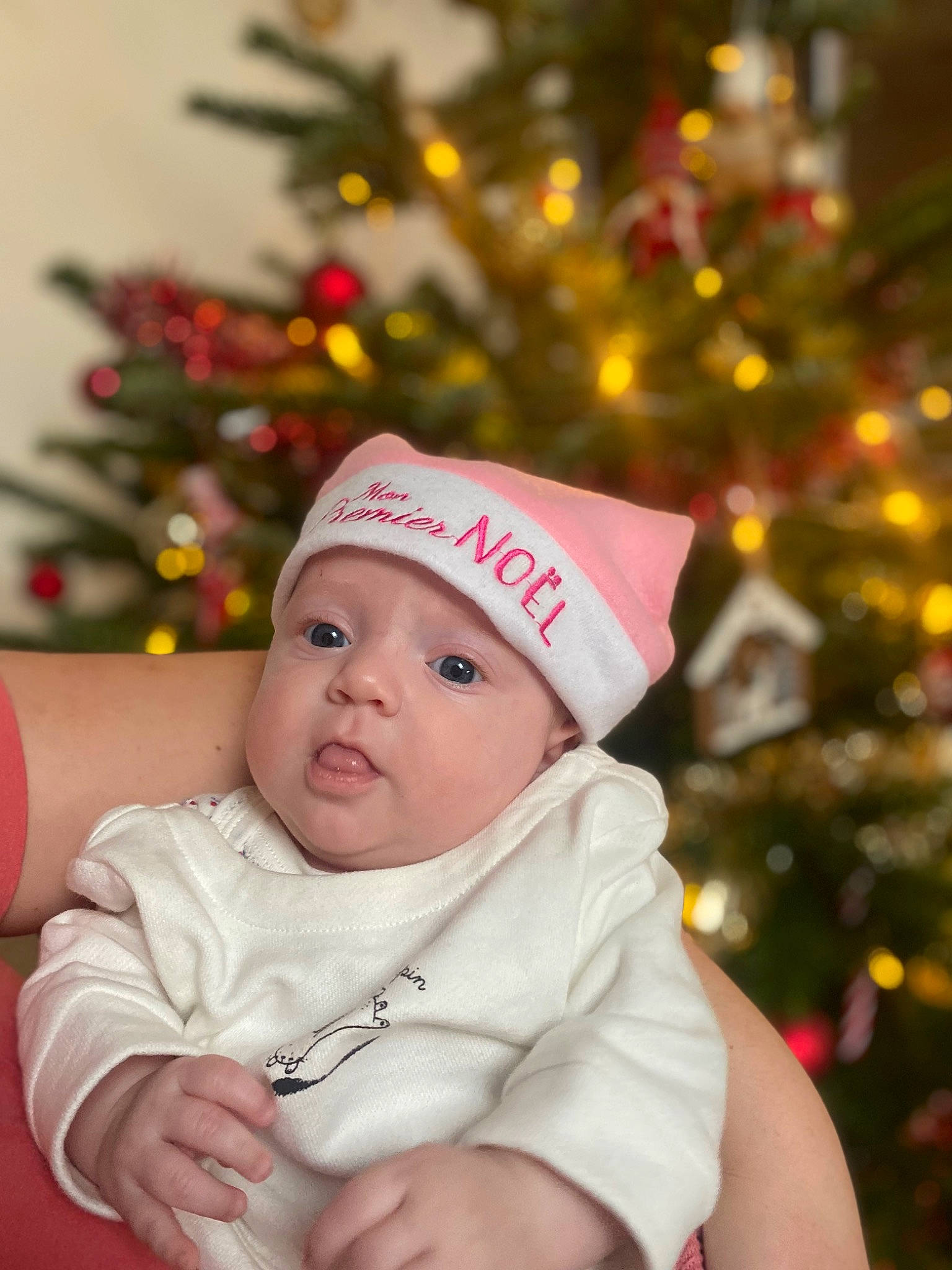 Angèle a rejoint le concours — aidez-le/la à gagner de superbes lots ! baby, baby_toddler_clothing, beauty, cap, child, christmas, christmas_decoration, christmas_ornament, christmas_tree, event, face, facial_expression, happy, headgear, headwear, holiday, holiday_ornament, human_body, ornament, person