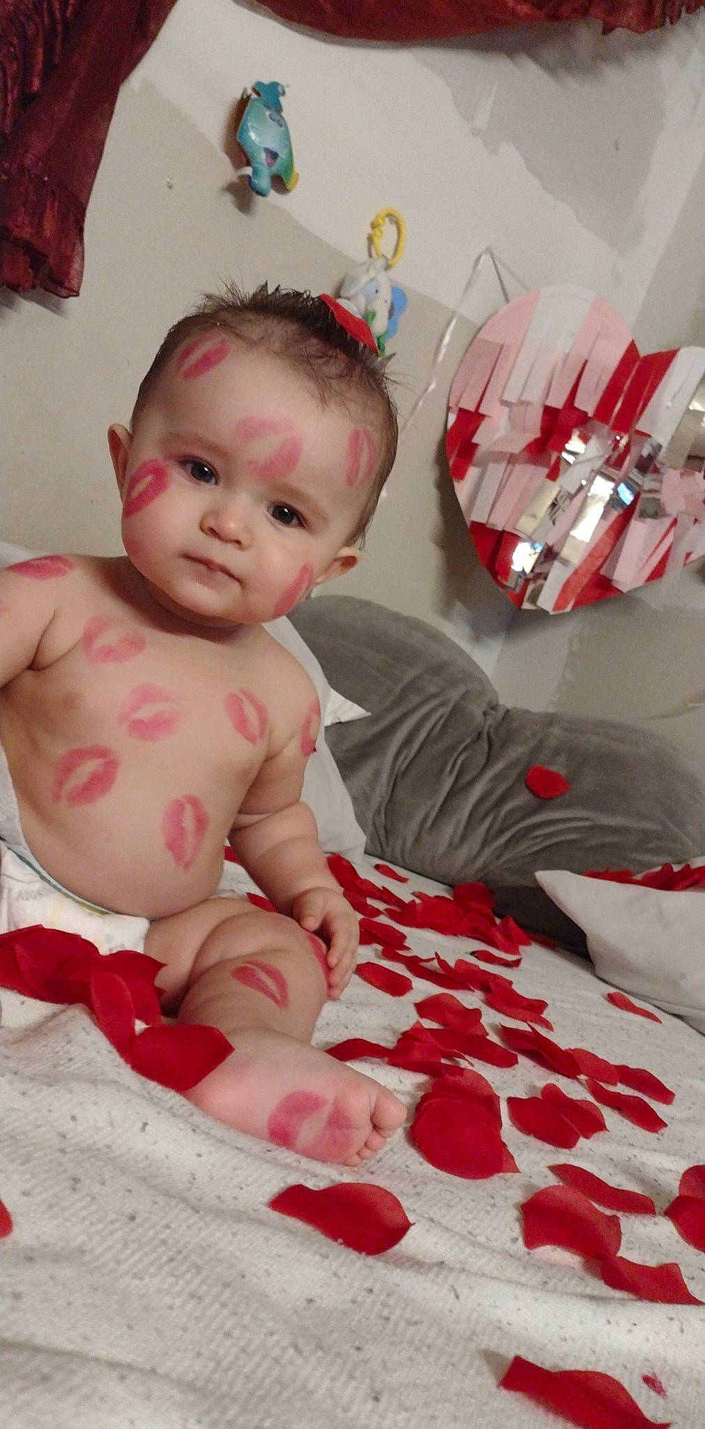 Omar is registered to the contest to win money with this photo: arm, baby, baby_toddler_clothing, beauty, cheek, child, comfort, finger, flooring, fun, happy, linens, mouth, person, pink, product, red, room, sitting, skin