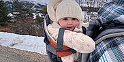 Lou a rejoint le concours — aidez-le/la à gagner de superbes lots ! baby, infant, stroller, baby_carrier, knit_hat, winter_coat, snow, mountains, cloudy_sky, outdoors, trees, road, gravel, smile, rosy_cheeks, bundled_up, cold_weather, scenic_view, family_walk, jacket