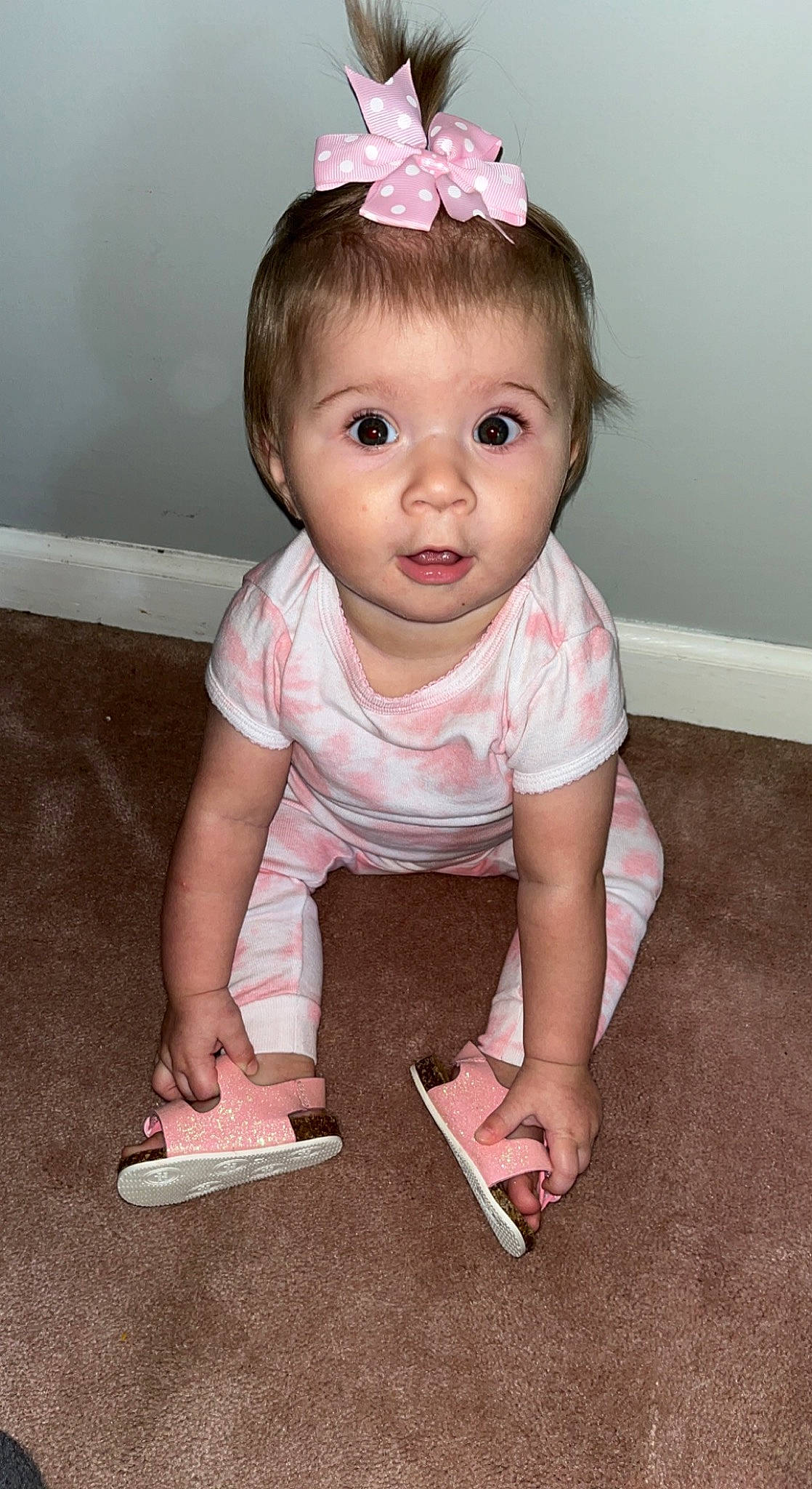 Taylyn is registered to the contest to win money with this photo: baby, baby_toddler_clothing, cheek, child, chin, dress, eye, eyelash, face, flooring, happy, iris, person, pink, sitting, skin, sleeve, smile, surprise, tiara