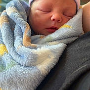 Dean is registered to the contest to win money with this photo: newborn, baby, sleeping, blanket, hat, pastel_colors, cozy, soft, infant, closeup, portrait, hospital, swaddled, child, peaceful, face, person, warm, resting, zipped_jacket