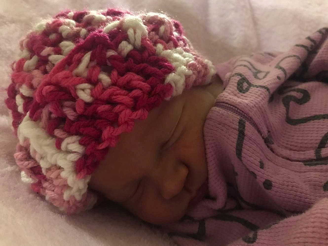 Harper is registered to the contest to win money with this photo: art, baby, baby_products, baby_sleeping, baby_toddler_clothing, cap, carmine, comfort, fashion_accessory, headgear, linens, magenta, nap, pattern, person, petal, pink, textile, toddler, wool