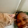 Kailyn Marie joined the competition — help win amazing prizes! cat, person, smiling, sleeping, bed, cozy, indoor, closeup, resting, orange_cat, human_face, braided_hair, blanket, comfort, relaxed, pet, friendship, warm, head, happy