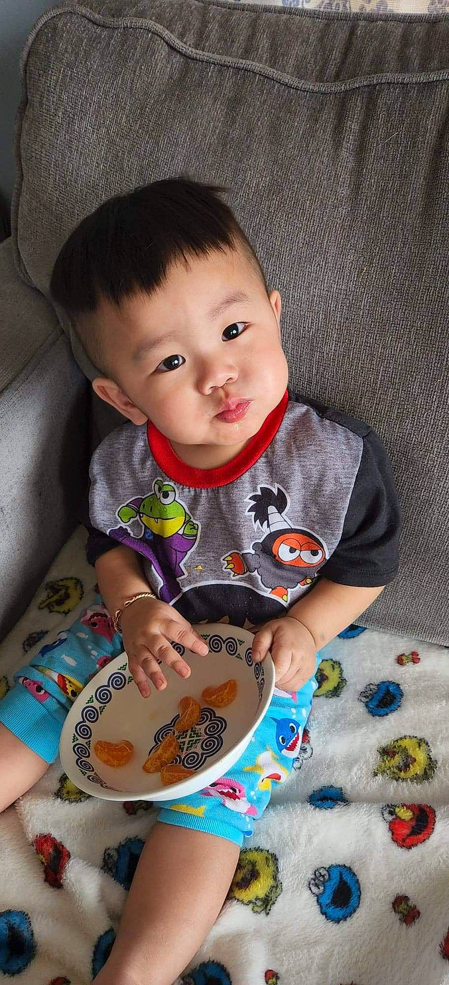 Keno is registered to the contest to win money with this photo: baby, baby_playing_with_toys, baby_toddler_clothing, bib, cheek, child, dress, flooring, fun, happy, musical_instrument, nose, pattern, person, play, product, sitting, skin, sleeve, t_shirt