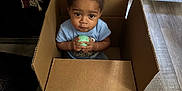 Nash Griffin joined the competition — help win amazing prizes! child, toddler, cardboard_box, toy_ball, indoor, wooden_floor, curious, seated, casual_clothing, home, flooring, person, small_child, looking_up, playful, iron, speaker, light_blue_shirt, hair_braids, floor_mat