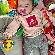 Tiya a rejoint le concours — aidez-le/la à gagner de superbes lots ! baby, pacifier, toy, play_mat, colorful, clothing, pink, gray_pants, indoor, child, cute, smiling, face, hand, foot, blanket, animal_print, adidas, infant, comfort