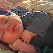 Oliver is registered to the contest to win money with this photo: baby, sleeping, blanket, bed, cozy, infant, peaceful, skin, face, hand, clothing, toddler, nap, cute, soft, comfort, rest, indoors, warm_light, relaxation