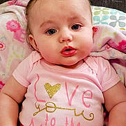 Harper is registered to the contest to win money with this photo: baby, child, pink_clothing, pigtails, blanket, cute, indoor, portrait, infant, sitting, face, expression, person, soft_toys, cozy, young_child, couch, closeup, happy, adorable